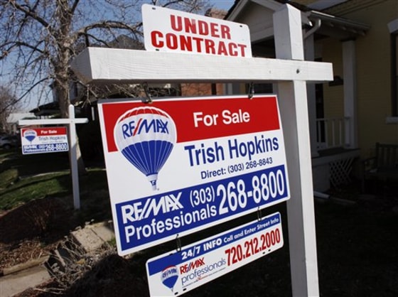 A sign noting the pending sale status of a single-family home tops the for sale sign in Denver. The number of buyers who agreed to purchase previously occupied homes rose sharply in February.